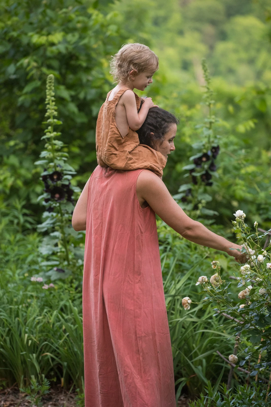 A mother laughing with her child outdoors in the green Asheville light